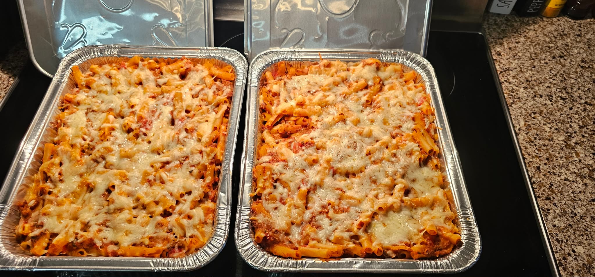 Fresh-baked ziti trays topped with melted mozzarella